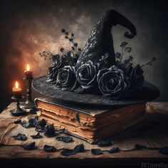 an old book with roses and a witches hat on it next to a lit candle