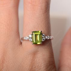 All HANDMADE ITEMS SHIP IN APPROX 8 DAYS Main Stone: Genuine natural peridot Main Stone Size: Emerald cut 6 mm x 8 mm Main Stone Weight: 1.64 carat Side Stone: CZs Height From The Ring Setting Bottom(to gemstone top): about 5.13 mm Width of Ring band Measure: gradually varied,about 1.67 to 1.91 mm Material: .925 Sterling Silver/14K White Gold/14K Yellow Gold/14k Rose Gold Engraved: Available For FreeNo more than 13 letters) Customized:Of course! Tell me what you want Includes With Order: All of Green Peridot Birthstone Ring With Prong Setting, Emerald Cut Peridot Ring For May Birthstone, Emerald Cut Peridot Gemstone Jewelry, Green Radiant Cut Diamond Ring As Gift, Green Radiant Cut Diamond Ring Gift, Emerald Cut Peridot Birthstone Ring, Emerald Cut May Birthstone Gemstones For Wedding, Green Emerald Cut Birthstone Ring With Accent Stones, Emerald Cut Green Gemstones For Anniversary