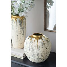 two vases sitting on top of a table next to each other with flowers in them