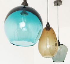 three different colored glass lamps hanging from the ceiling