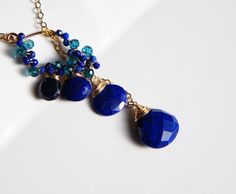 "Lapis lazuli, mystic london blue topaz and sapphire, beautiful navy blue gemstones cluster lariat necklace. They are light weight, will match with pair of jeans or fancy dress. Please a drop through a pandant twice for being stable. All material is 14K gold filled Lapis lazuli drop approx 8, 10mm The length of the pendant is 1.8\" ( 4cm) Chain 18\" or 20\" please select a length Comes in a gift box Matching earrings is available, https://www.etsy.com/listing/493628400/lapis-lazuli-drop-earrings Blue Lariat Necklace For Gift, Blue Lariat Jewelry With Adjustable Chain, Blue Long Drop Necklace As A Gift, Blue Long Drop Necklace As Gift, Blue Long Drop Necklace For Gift, Blue Gemstone Lariat Necklace, Blue Dangle Jewelry With Adjustable Chain, Blue Sterling Silver Lariat Jewelry, Blue Lariat Necklace With Natural Stones