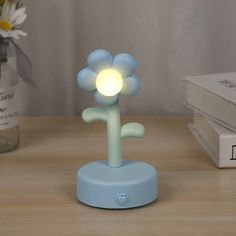 a blue flower lamp sitting on top of a wooden table