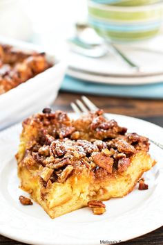 a slice of pecan pie on a plate with a fork and bowl in the background