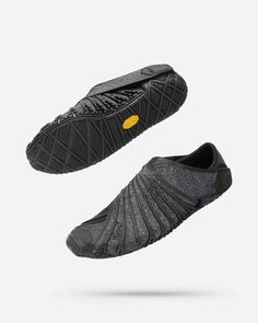 a pair of black shoes with yellow soles on the top and bottom, side by side