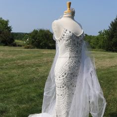 a wedding dress on display in the grass