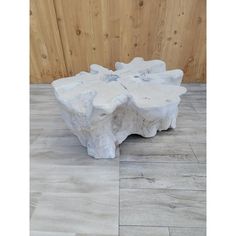 a white stone bench sitting on top of a wooden floor