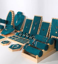 an assortment of jewelry on display in wooden boxes with matching necklaces and bracelets