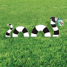 a black and white snake in the grass with a butterfly on it's tail