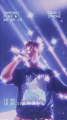 a man standing on top of a stage holding a microphone in front of his face