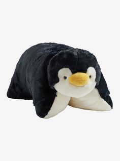 a black and white stuffed penguin laying on its side with it's eyes closed