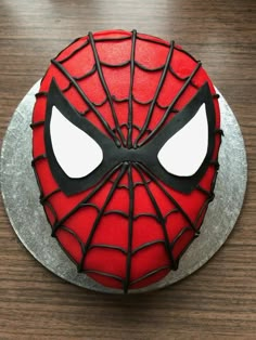 a spider - man cake is decorated with chocolate icing