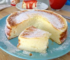 a blue plate topped with a cake covered in powdered sugar on top of a wooden table