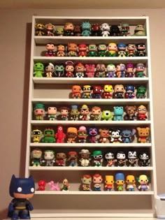 a shelf filled with lots of different types of pop culture figurines on top of it