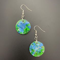 Elevate your style with these one-of-a-kind resin circular earrings, featuring a harmonious blend of blue and green hand-dyed shells set against a clear, white background. The circular shape embodies unity and eternal beauty, while the calming blue and refreshing green hues evoke tranquility and renewal. Handcrafted with care, these unique earrings offer a touch of serene elegance and meaningful artistry.  Materials: Crafted from hypoallergenic, crystal-clear resin, these earrings ensures both c Clear White Background, Circular Earrings, Art With Meaning, Eternal Beauty, Green Hand, Green Hues, With Meaning, Clear White, Jewelry Unique