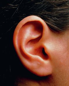 a woman's ear is shown with the top part of her ear pierced down