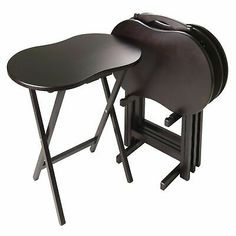 two black folding chairs with one sitting on the back and another standing up against it