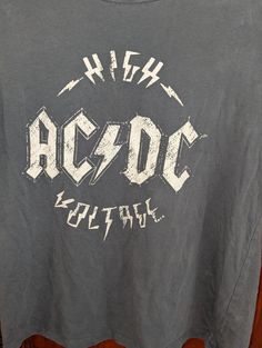 Vintage AC/DC High Voltage T-Shirt Rock Style T-shirt With Band Logo For Music Festivals, Rock And Roll Graphic T-shirt For Music Festival, Rock Style Band Logo T-shirt With Crew Neck, Band Merch T-shirt With Logo For Concert, Rock Style Crew Neck T-shirt For Music Festival, Rock Style Band Logo T-shirt For Summer, Rock And Roll Graphic Crew Neck Top, Rock And Roll Crew Neck Top With Graphic Design, Rock Style Graphic Design Short Sleeve T-shirt