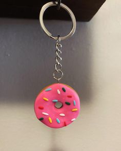 a pink doughnut with sprinkles hanging from a key chain