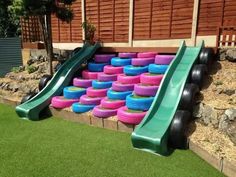 a green slide with pink and blue tires on it