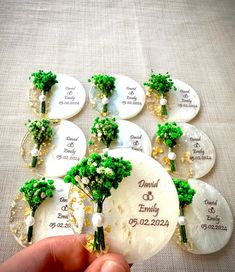 a person holding a bunch of brooches on top of a table