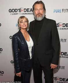 a man and woman standing next to each other on a red carpet at an event