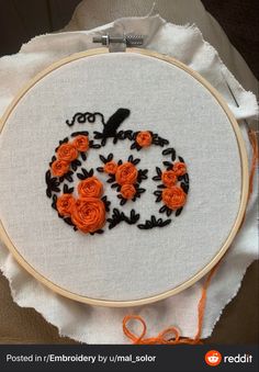 an embroidered pumpkin with orange roses on it