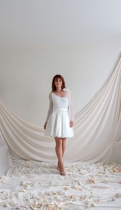 a woman standing in front of a white backdrop