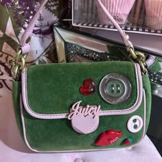 Absolutely Adorable Y2k Vintage Juicy Couture Mini Bag! Love This Colorway!! Soft Green Velour With Baby Pink Trim Front Features Pink Heart With Juicy Magnetic Closure Different Buttons, Hearts, Lips With Juicy And The Cutest Little Strawberry Plastic Accents Back Has Juicy Couture In Pink Embroidery Pink Fabric Top Strap Interior Is Tan With Matching Green Crown Logo Lining Zipper Interior Pocket With J Pull Great Vintage Condition. Only Flaws I See Is One Spot On Back(I Haven’t Tried To Clean). Inside Is Clean Just Some Light Discoloration Around The Edging Of Top Flap Inside. See Measurements As This Is A Small Size Bag 8”W 6”H 1.5”D One Of My Favorites From My Collect Green And Pink Packaging, Pink Shopping Cart, Weird Bags, Vintage Magnets, Pink Mini Bag, Funky Purses, Juicy Couture Vintage, Green Crown, Strawberry Heart