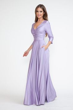 a woman in a long purple dress posing for the camera with her hands on her hips