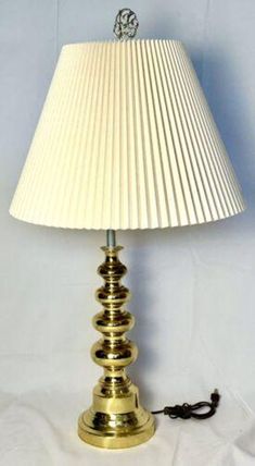 a lamp that is on top of a white table cloth with a cord attached to it