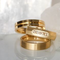 two gold wedding bands with diamonds on them