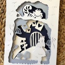 a white card with black and white paper cut out of it