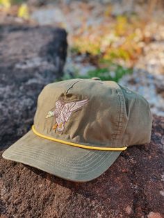 Providing lightweight sun protection with a classic fit, this hat is perfect for everyday work or play. Back has an adjustable strap. Embroidered Mallard patch. Embroidered Logo Custom Prairie Oaks Waterfowl Design Adjustable Button Closure One size fit most Summer Military Cotton Hat, Military Style Cotton Hat For Summer, Summer Military Style Cotton Hat, Vintage Cotton Hat For Outdoor Activities, Adjustable Cotton Snapback Hat For Beach, Military Style Baseball Cap With Short Brim, Cotton Flat Bill Hat For Outdoor Activities, Military-style Cotton Snapback Hat, Adjustable Khaki Baseball Cap For Beach