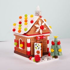 a toy house with candy on the roof and christmas decorations around it's base