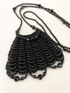 "A beautiful black knitted bag made by me with black Czech seed beads and all black accent beads. The bag feels wonderfully soft to touch. These are all good quality beads. No plastic!! The necklace strap measures 28\" The bag measures approx. 2 1/4\" x 2 3/4\"" Black Beaded Bags As Fashion Accessory, Black Beaded Bag As Fashion Accessory, Evening Black Beaded Necklaces, Black Beaded Necklace As Fashion Accessory, Black Beaded Necklaces For Fashion, Black Handmade Beaded Necklaces For Evening, Black Beaded Chain Necklaces For Evening, Handmade Black Necklace For Evening, Elegant Black Necklace For Everyday Use