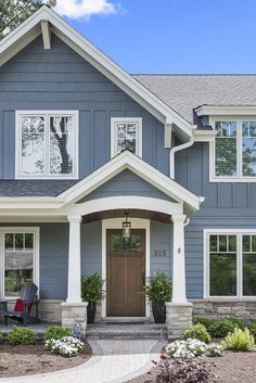 a house with blue siding and white trim on the front door is shown in this image