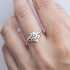 a woman's hand with a diamond ring on top of her finger and an engagement band