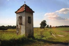 an old church tower in the middle of a field