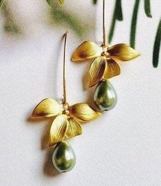 "* Beautiful Matte Gold Orchid flowers create a delicate look for Bridesmaids Earrings, and they are beautifully accented by lovely Mossy Green Glass Teardrop Pearls. * The Earrings are created with beautiful 14K Gold Filled * The total length of these earrings is 1 3/4\" (42mm), and the Sage Green Teardrop Pearls measure 9mm x7mm. I also offer several different shades in the Swarovski Pear Teardrop Collection. Please add a note at checkout if you wish to exchange colors. * Each pair of these We Gold Dangle Flower Earrings For Bridesmaids, Gold Teardrop Flower Earrings For Formal Events, Delicate Gold Teardrop Flower Earrings, Gold Dangle Earrings With Flower Decoration, Elegant Handmade Flower Earrings For Bridesmaids, Gold Flower Earrings With Ear Wire For Formal Occasions, Gold Flower Earrings For Bridesmaid Gift, Gold Flower Earrings For Bridesmaids, Delicate Green Flower Earrings For Wedding