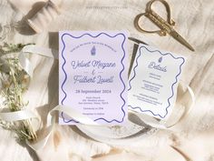 wedding stationery with scissors and flowers on the table