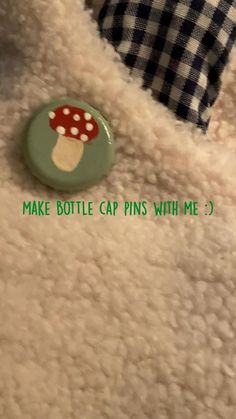 a close up of a button on a teddy bear's coat with the words make bottle cap pins with me