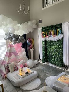 a living room filled with balloons and furniture in front of a sign that says cloud