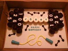 a birthday cake in a box with scissors and dog bones on the side that says happy birthday