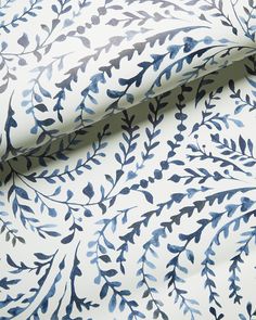 a blue and white wallpaper with leaves on it