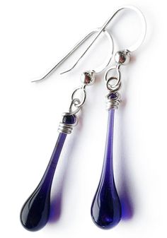 The deep, dark purple of these simple yet elegant glass earrings evoke the smooth flow of molten glass, frozen forever in an elegant drop of glass. Whether you’re running a few errands or dressing up for an evening, these deceptively simple glass earrings will add the finishing touch to any outfit. Earring length: 1 3/8" - 1 5/8" including hook Eco-friendly jewelry, made from a scrap of stained glass melted with focused sunshine Recycled sterling silver findings are nickel free and hypoallergeni Elegant Glass Drop Earrings, Minimalist Teardrop Glass Jewelry, Modern Glass Teardrop Earrings, Elegant Glass Drop Jewelry, Elegant Drop Glass Jewelry, Elegant Drop-shaped Glass Jewelry, Glass Drop Earrings For Formal Occasions, Elegant Nickel Free Glass Earrings, Elegant Nickel-free Glass Earrings