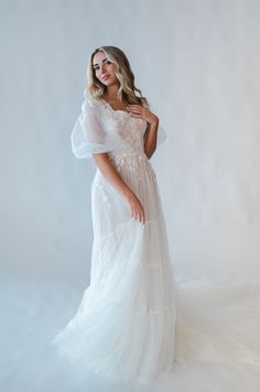 a woman in a white dress posing for the camera with her hands on her hips