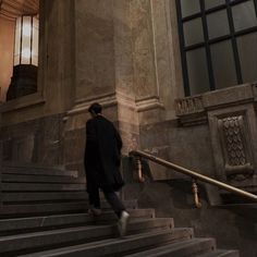 a man walking up some stairs in front of a building