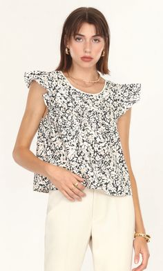 Ruffled sleeves, a thin lace along the neckline, and a squared open-back. This top ties all of that together with a lovely flower print to create a fun, relaxed spring blouse. The fit feels like a loose tank top because the ruffled sleeves extend from the shoulders instead of resting on them. The material is made up of Spring Blouse, Loose Tank Top, Spring Blouses, Loose Tank, A Beautiful Flower, Loose Tank Tops, Poplin Top, Ruffled Top, Luxury Women Fashion