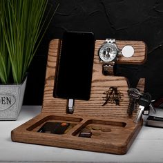 a wooden watch and cell phone holder on a desk