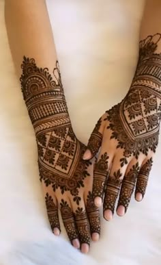 two hands with henna tattoos on them